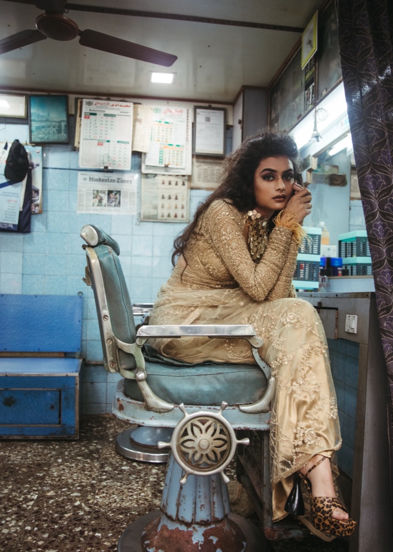 Champagne zari saree in a century-old Kolkata barbershop — jewel-tone couture in a lived-in world