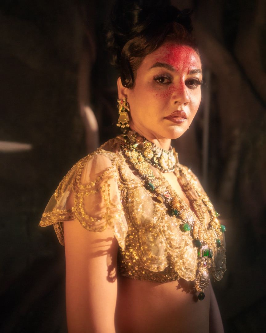 Golden scallop blouse and emerald jewels in candlelight — the gallery’s atmosphere
